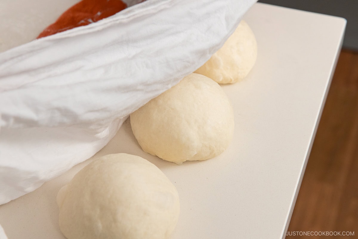 Resting the dough under the damp cloth.